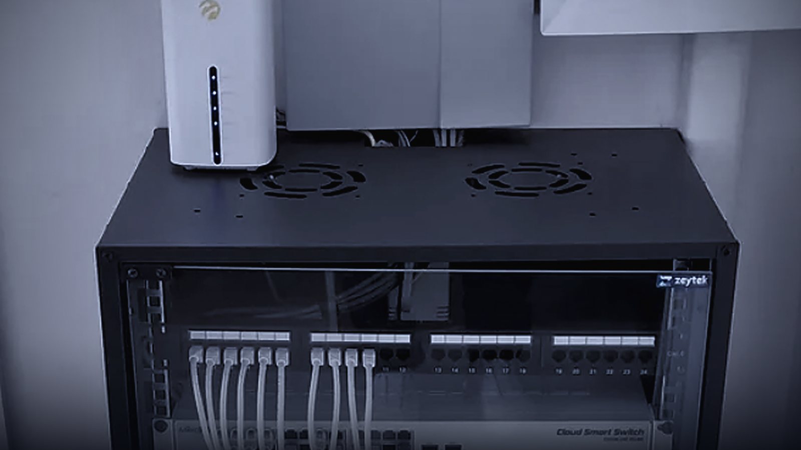 Duvara monte kabin içinde modem, patch panel ve bulut yönetimli switch